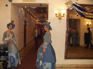 Зеркало и две дамы в платьях у входа